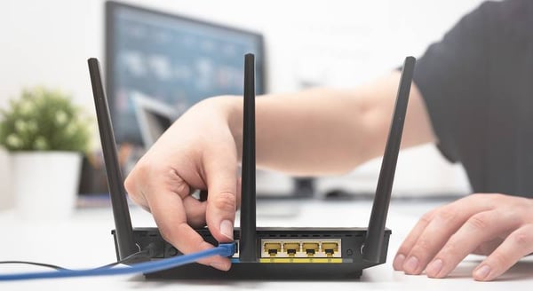<img src="hand-plugging-ethernet-into-router.png"  alt="cybersecurity-home-defense-how-to-secure-your-wfh-network">